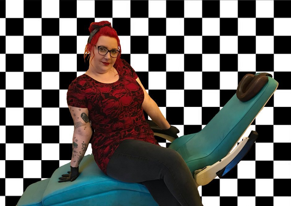 Marie sitzt auf dem türkisen Piercing-Stuhl im Studio